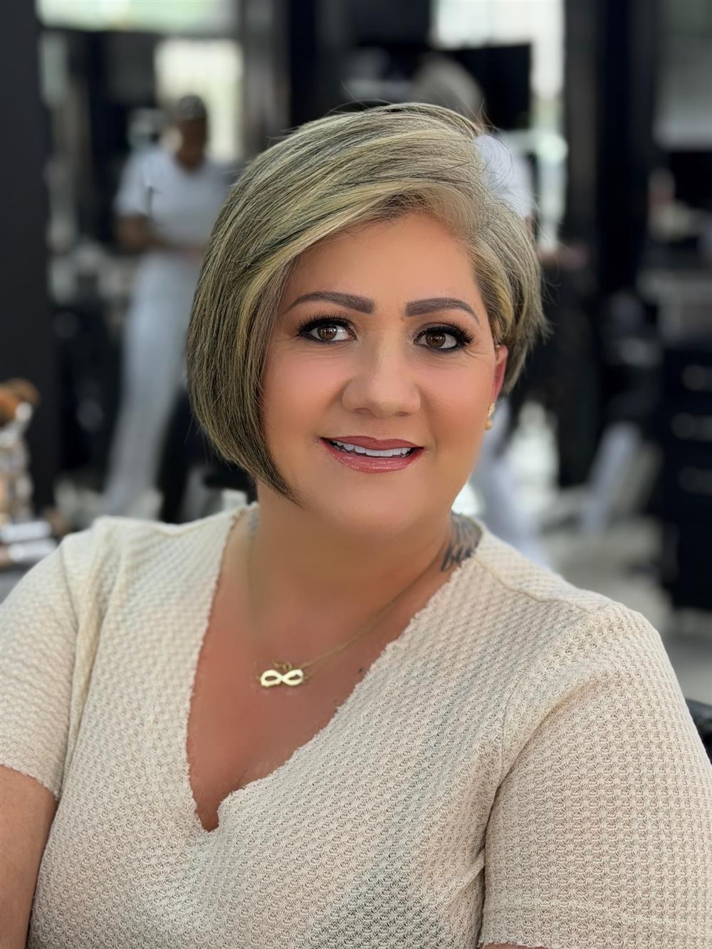 Clienta sonriente con corte bob y mechas plata