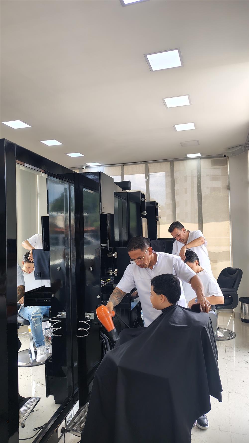 Estilista haciendo un corte de caballero en el salón