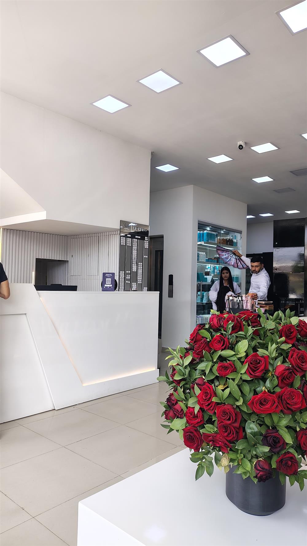 Recepción blanca con un gran arreglo de rosas rojas